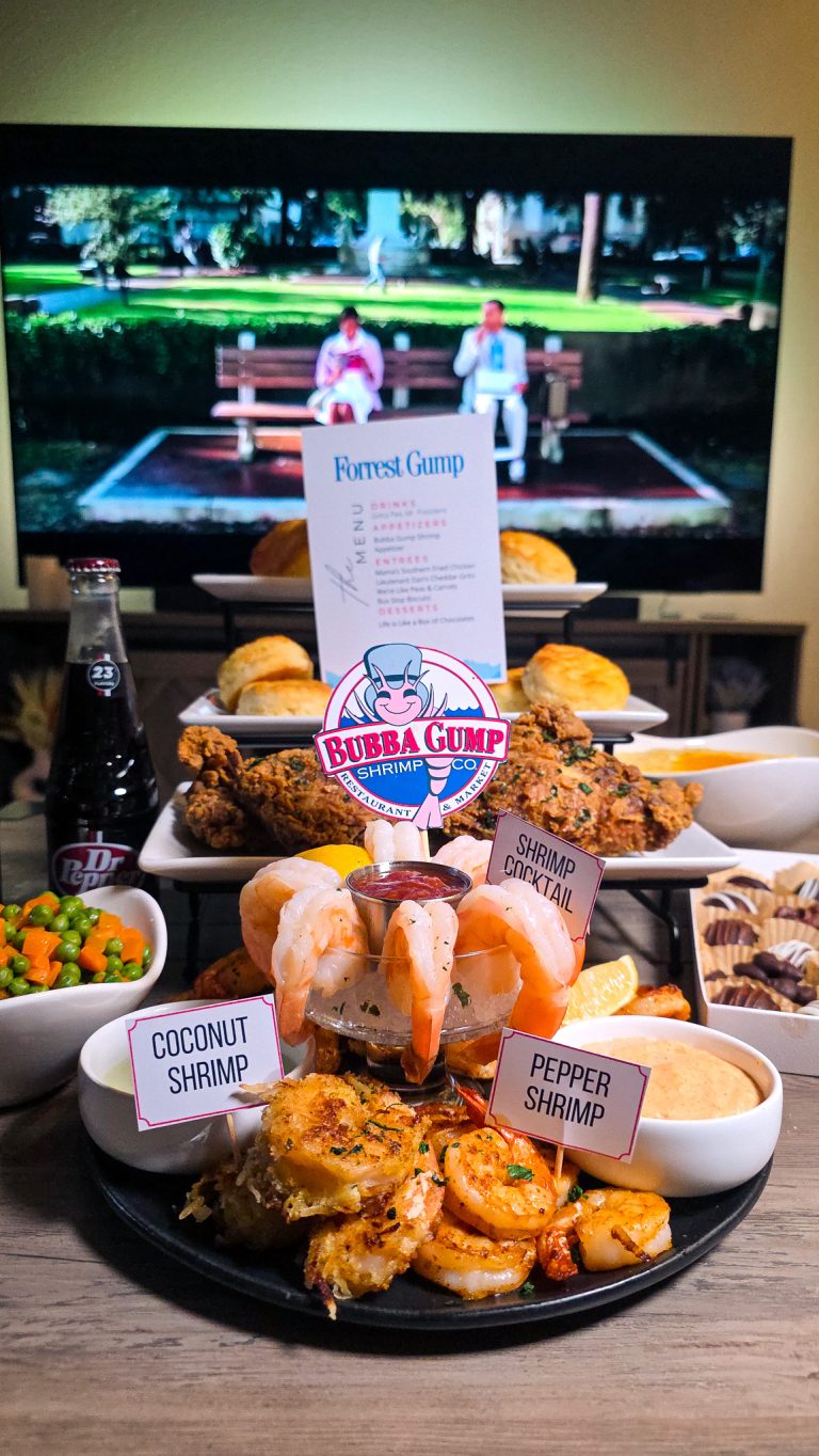 Wide shot of Forrest Gump dinner and movie night with bench scene on TV and full spread on coffee table